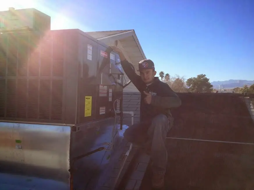 HVAC technician performing HVAC Inspection on a rooftop unit in Castroville